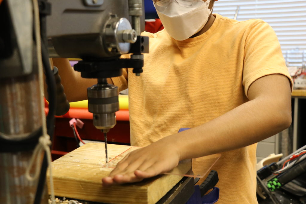 A team member working on the drill press.