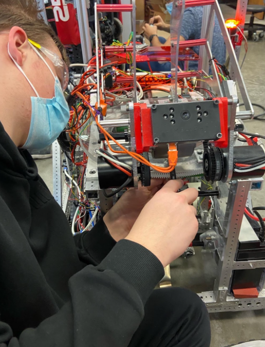 A team member working on the turret that is on the robot