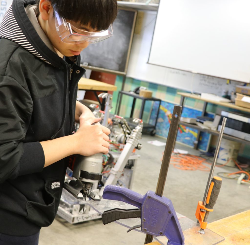 a student cutting plexy-glass