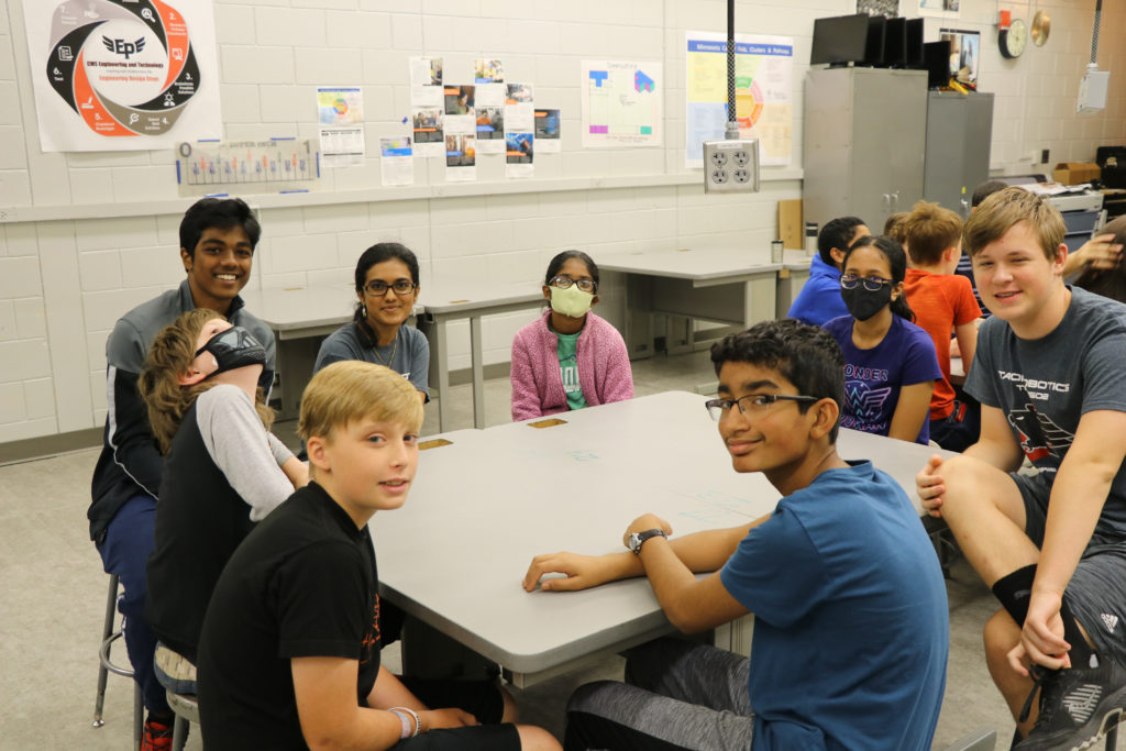 A group of students and talon team members smiling toward the camera as their picture is getting taken.