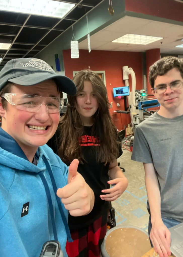 two students and a mentor posing for a photo during the open room.