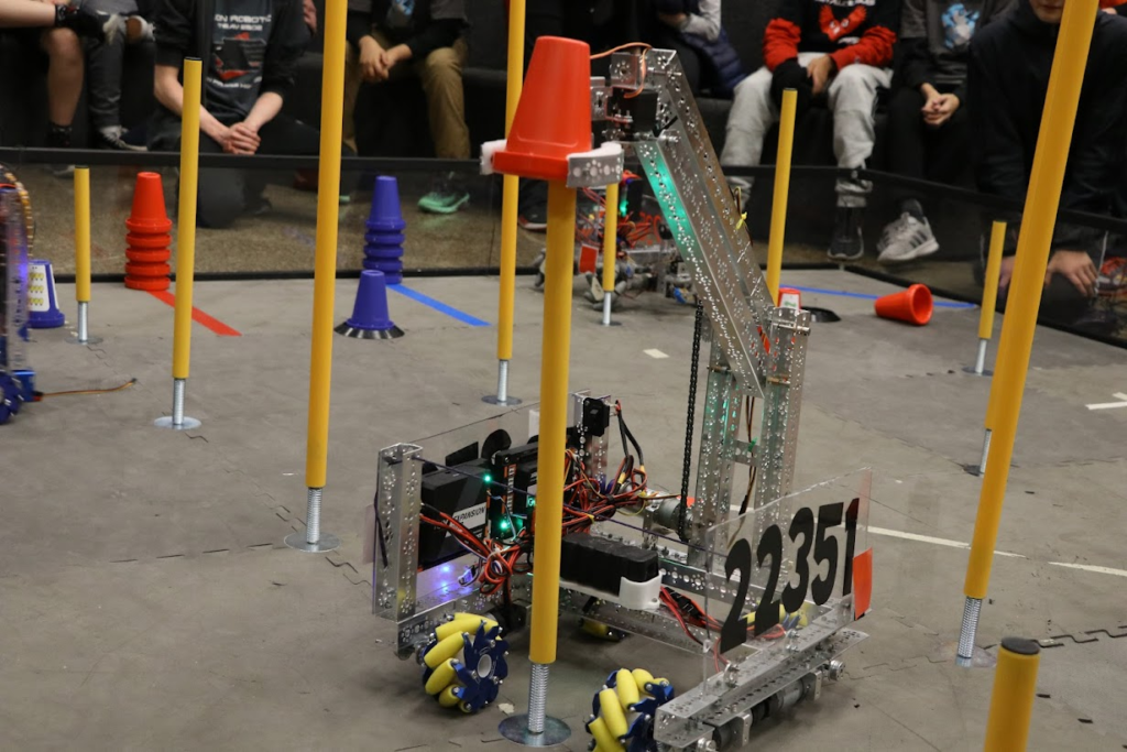 a robot picking up a cone and placing it the pillar