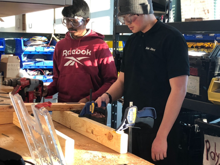 Two team members inspecting wood
