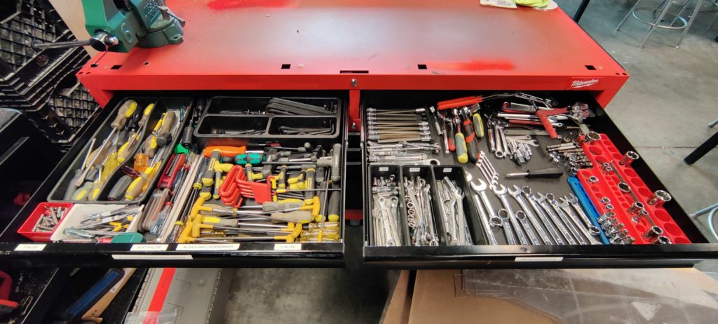 a photo of a organized tool cart. Multiple sets of wrenches and screwdrivers perfectly organized.