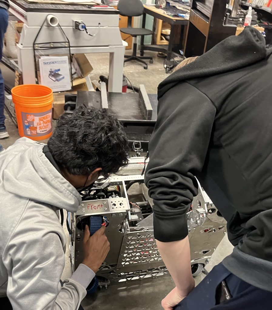 two students looking at the drive train 