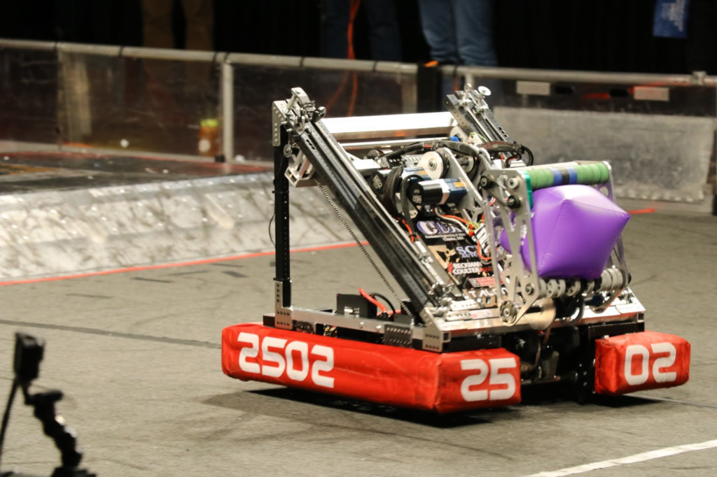 The robot on the field holding a cube in its stowed position 