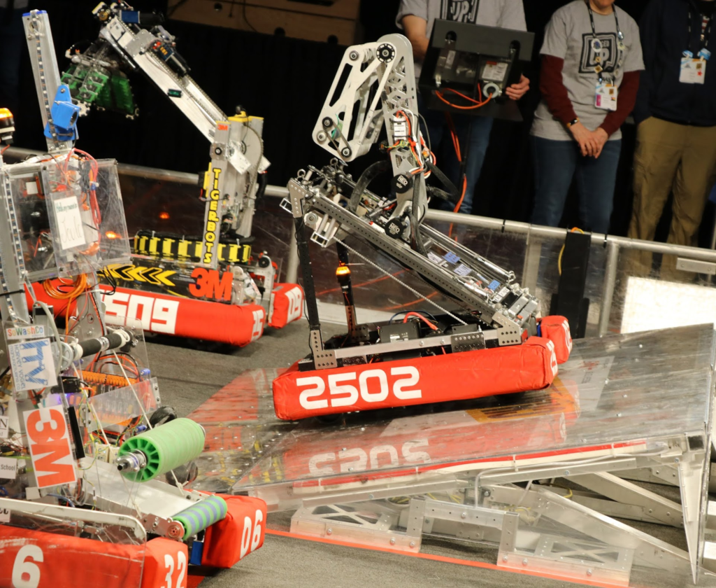 The robot starting to scale the charging station. in its stowed position in red bumpers