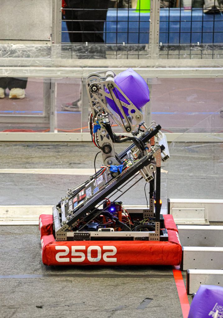 the robot holding a FIRST purple cube in the air with its intake