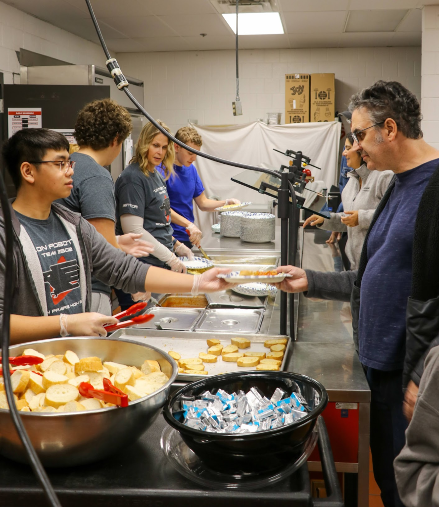 Students and mentors serving food