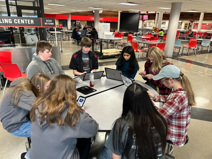 A small group of eight reading the rules on their laptop