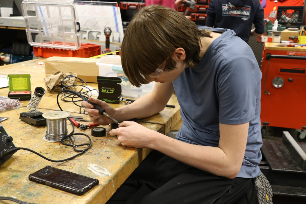 One student working on a soldering iron. 