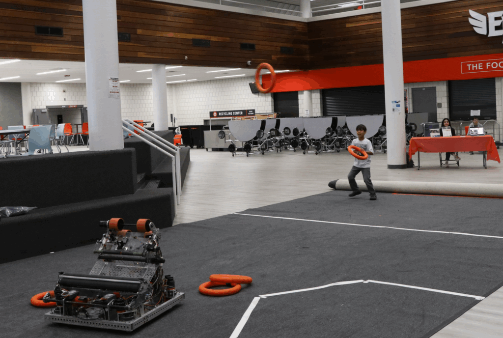 A kid catching foam rings being shot by one of our robots