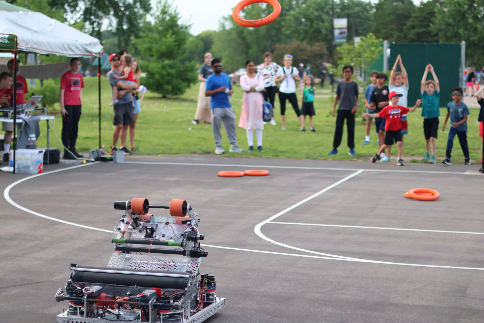 Cronus shooting notes to a large crowd of children as parents watch