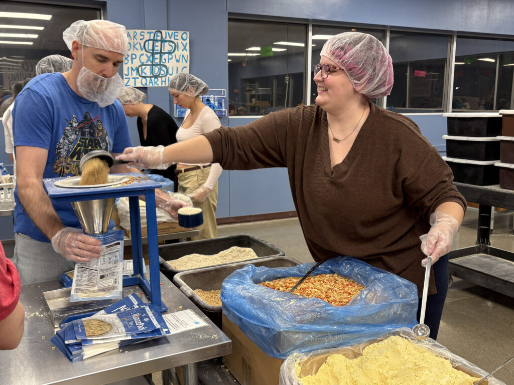 Our mentors are filling Manna Pack bags with rice and soy!