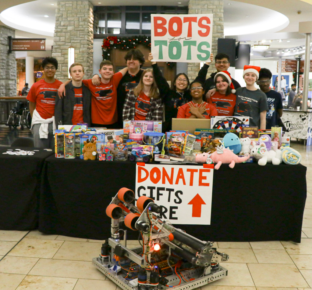 Talon team members stand around a table piled with toys.