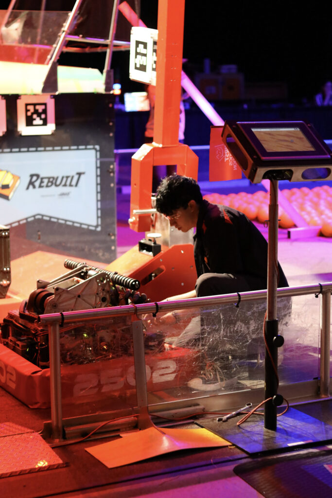 A team member working on our robot on the field