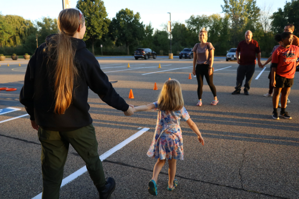 Ally walking with a child at an Outreach event