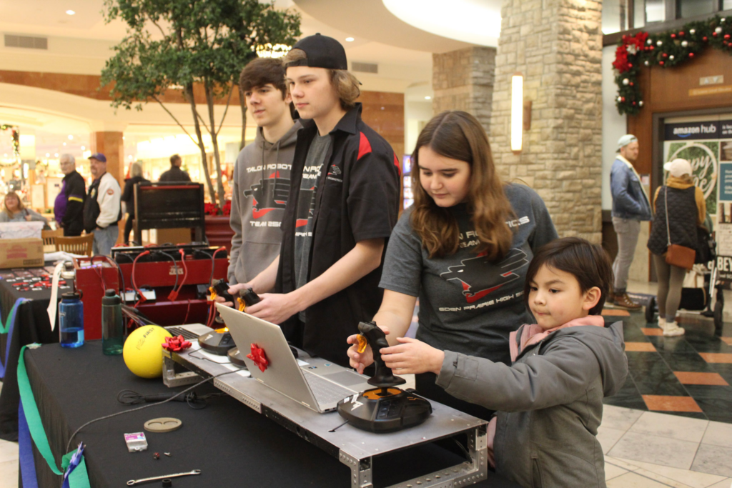 Charlotte helping a kid draw the robot