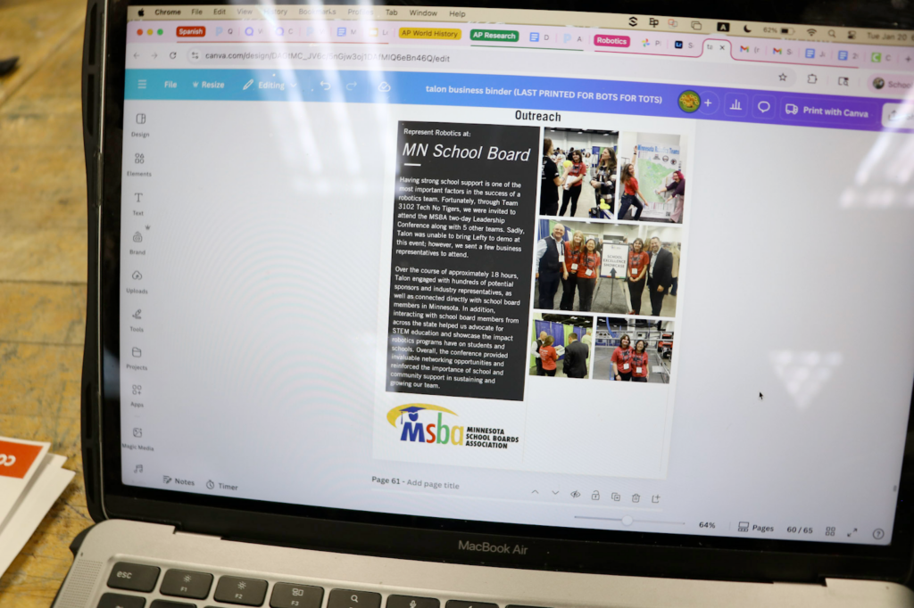 A picture of her laptop with a business binder page being worked on