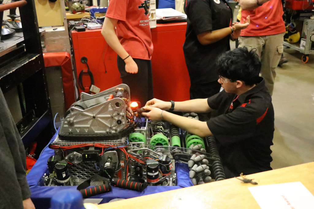 A member of drive team working on the robot after a match