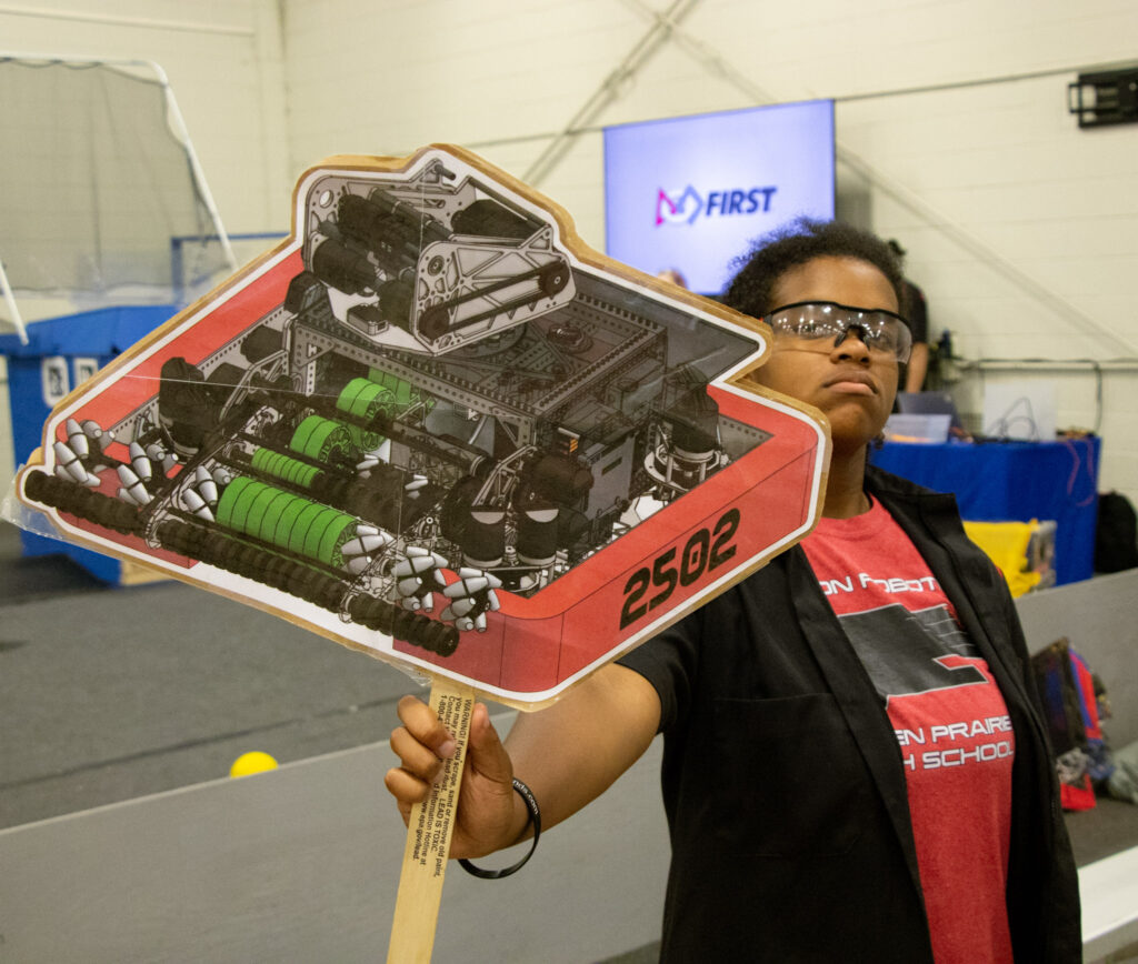 A team member holds up a cutout of Dippy on a stick to be marched later in the parade